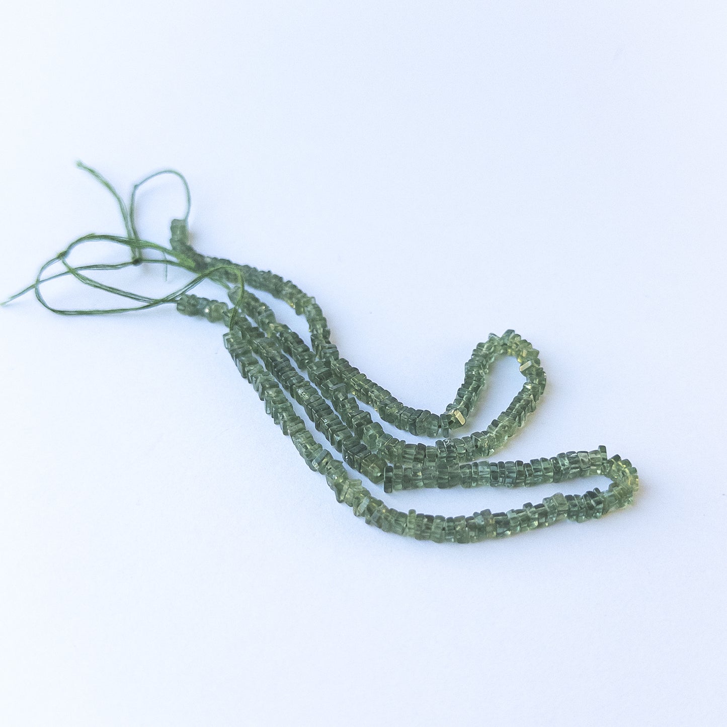 Authentic green apatite gemstone beads showcasing vibrant green tones and uniform heishi cut.