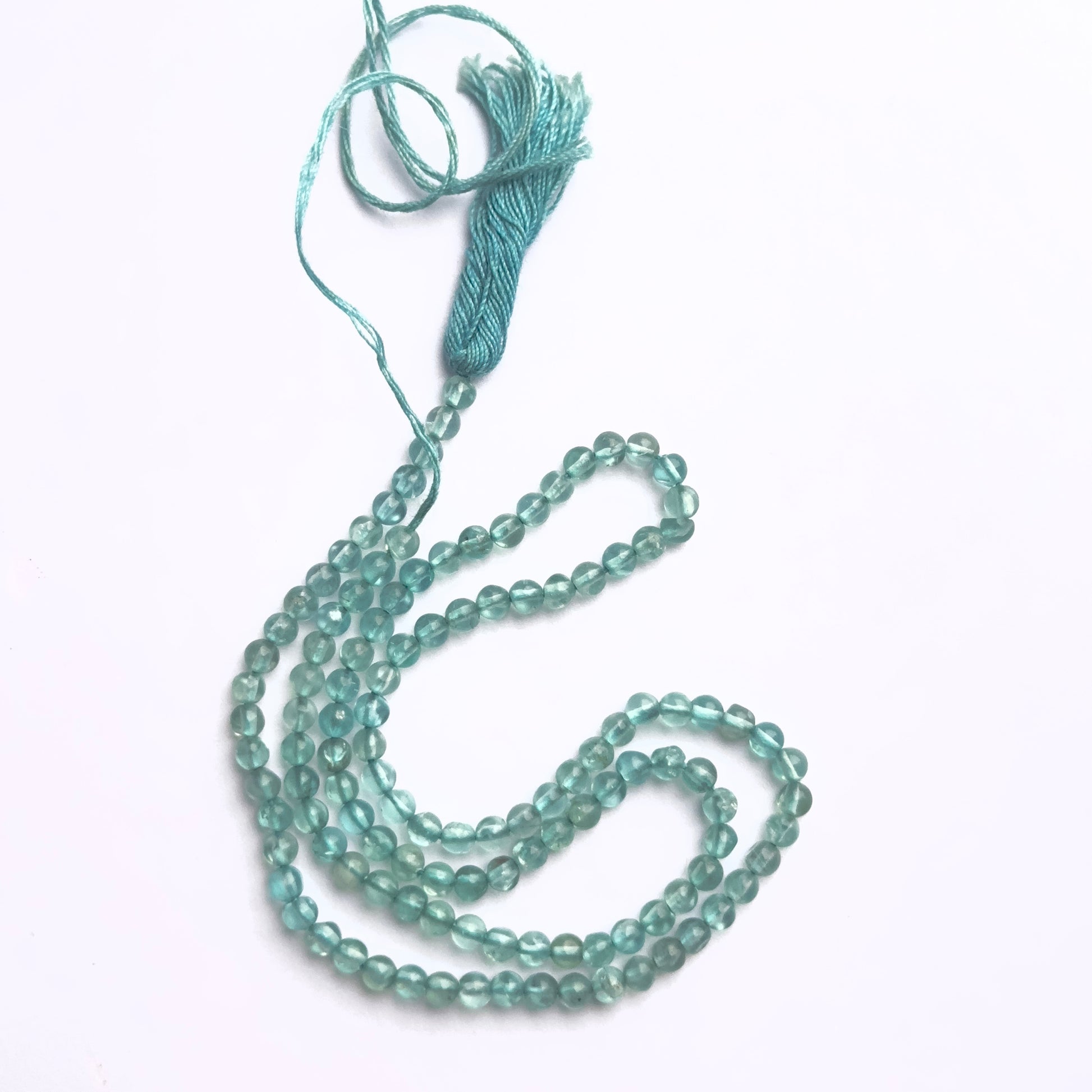 Close-up of Apatite gemstone beads showing smooth round cut and polished finish.