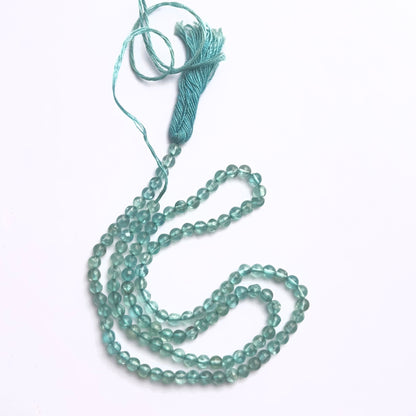 Close-up of Apatite gemstone beads showing smooth round cut and polished finish.