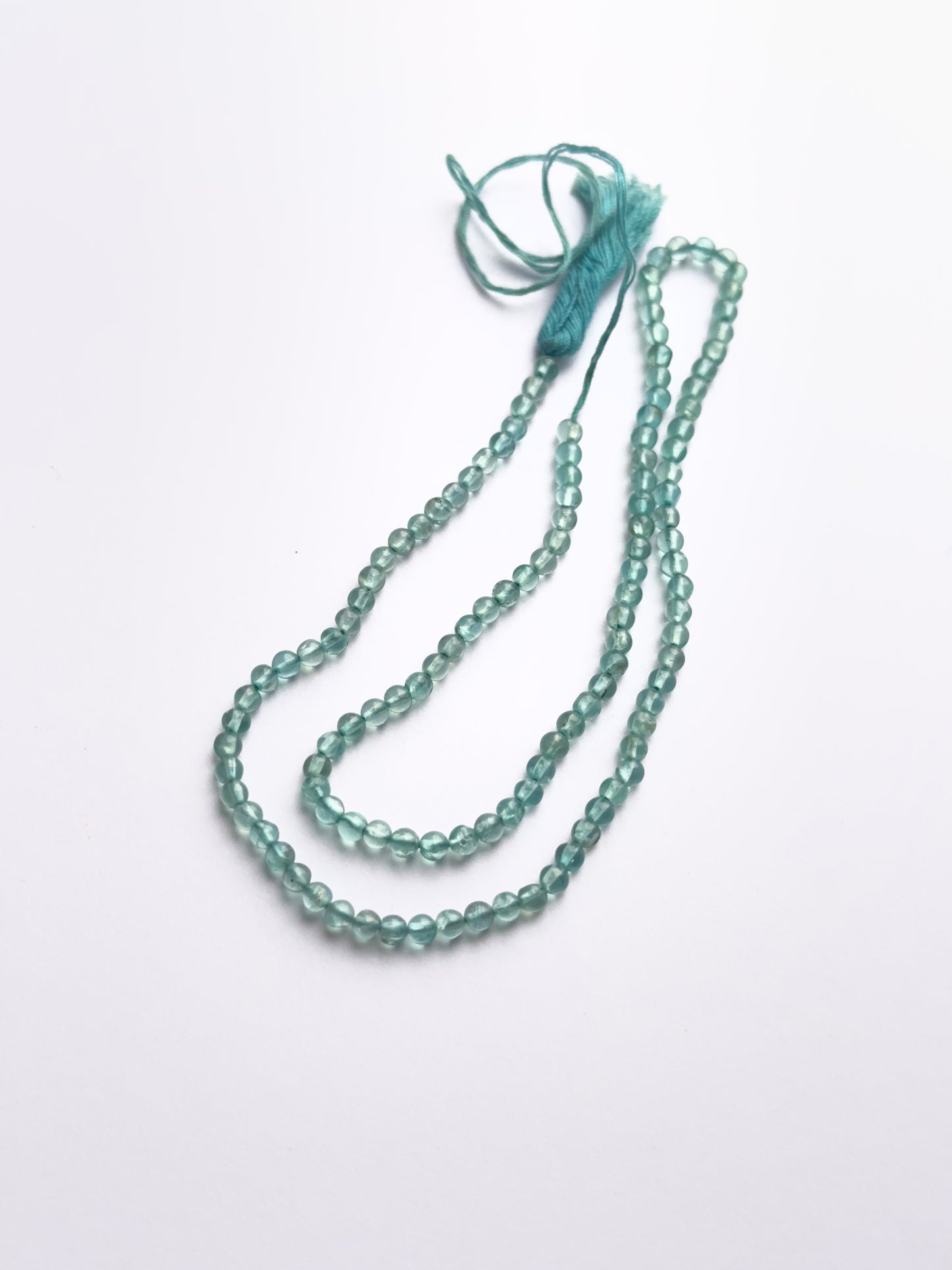 Natural Apatite stone beads arranged in strands with glossy surface and shine.