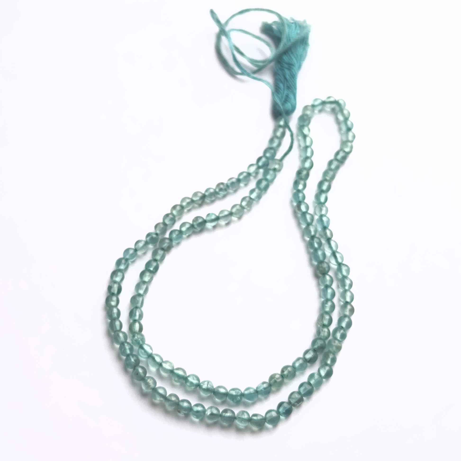 Apatite smooth round beads in vibrant blue-green tones strung in a 33cm strand.