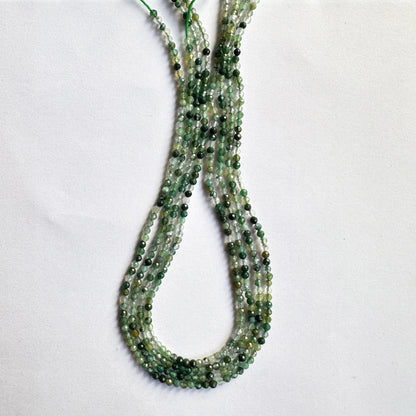 Close-up of green aventurine faceted rondelle beads highlighting their translucent green tones and fine cut.