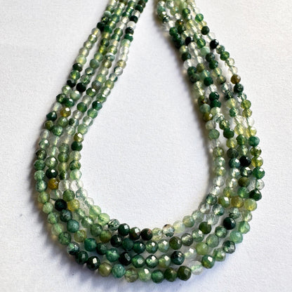 Loose green aventurine faceted rondelles spread out to reveal their clarity and uniformity.