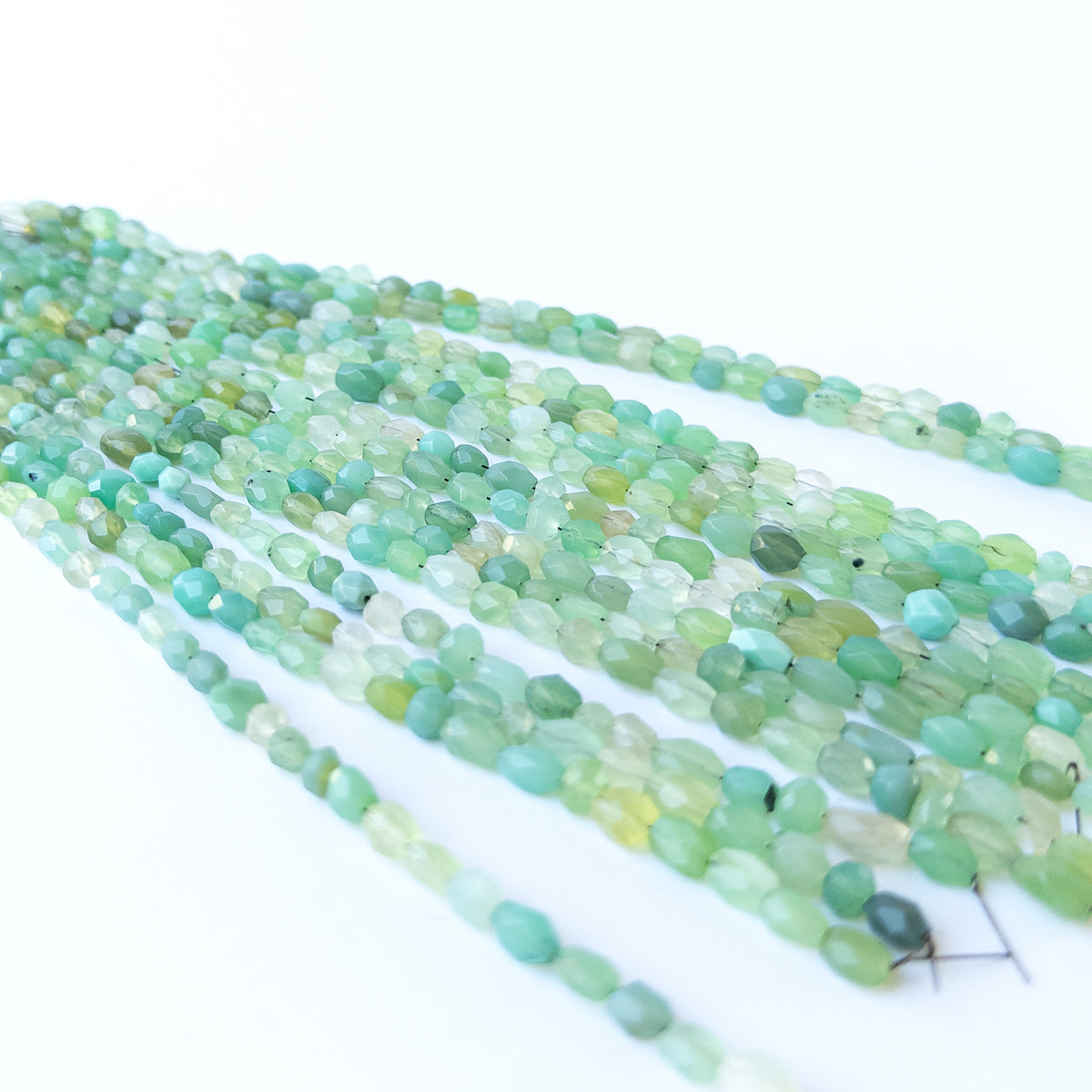 Close‑up of Green Chalcedony faceted oval beads revealing clarity, shine and fine craftsmanship.