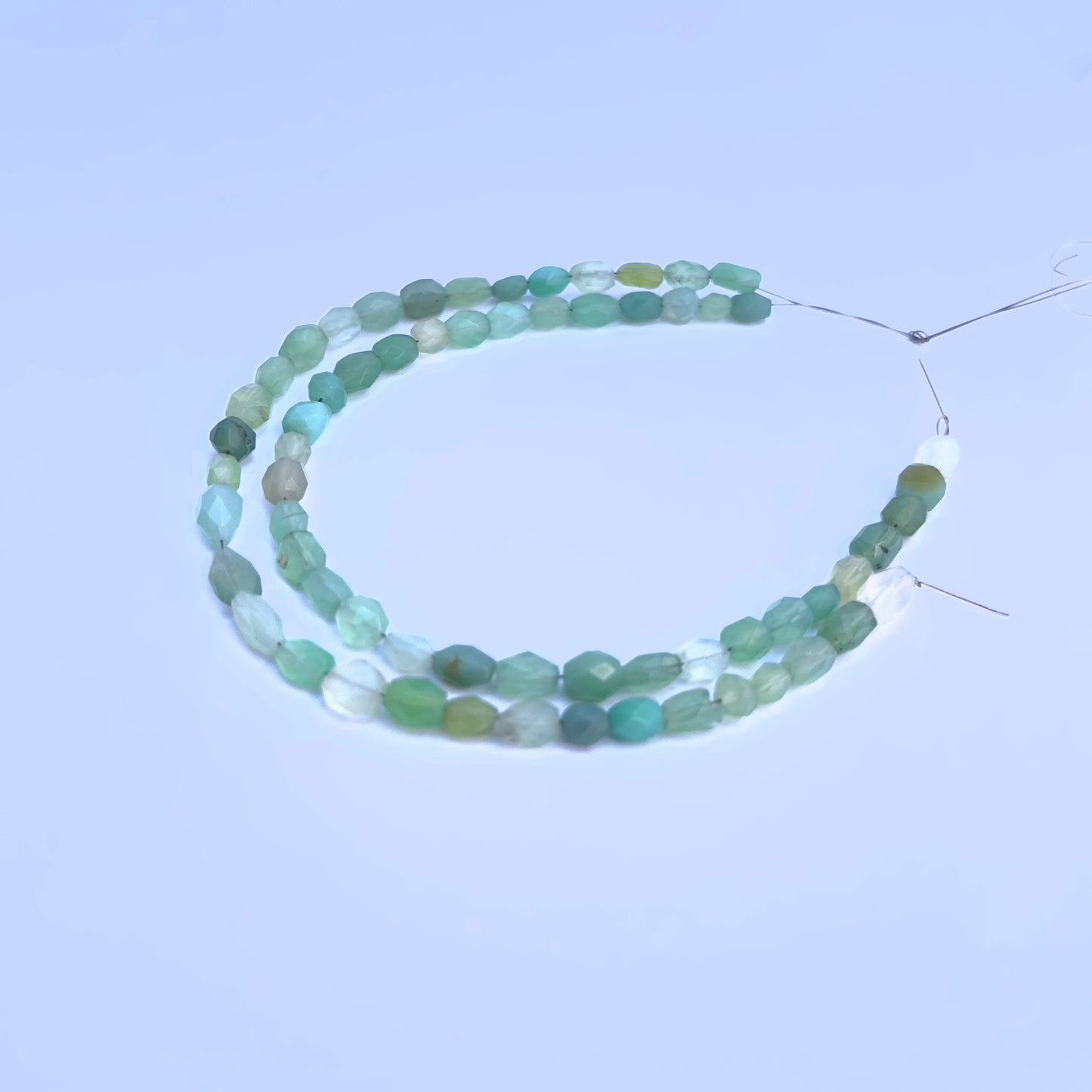Natural Green Chalcedony stone beads arranged in strands with luminous green hues.