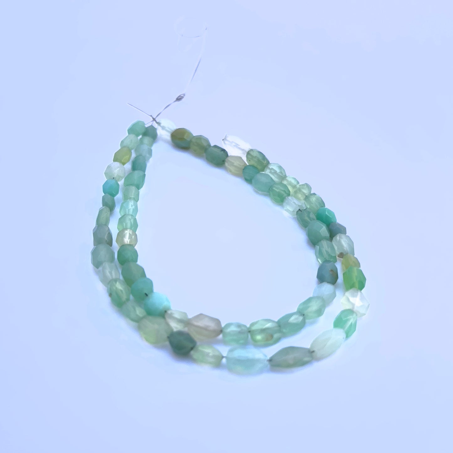 Green Chalcedony gemstone beads for jewellery making displayed with soft lighting.