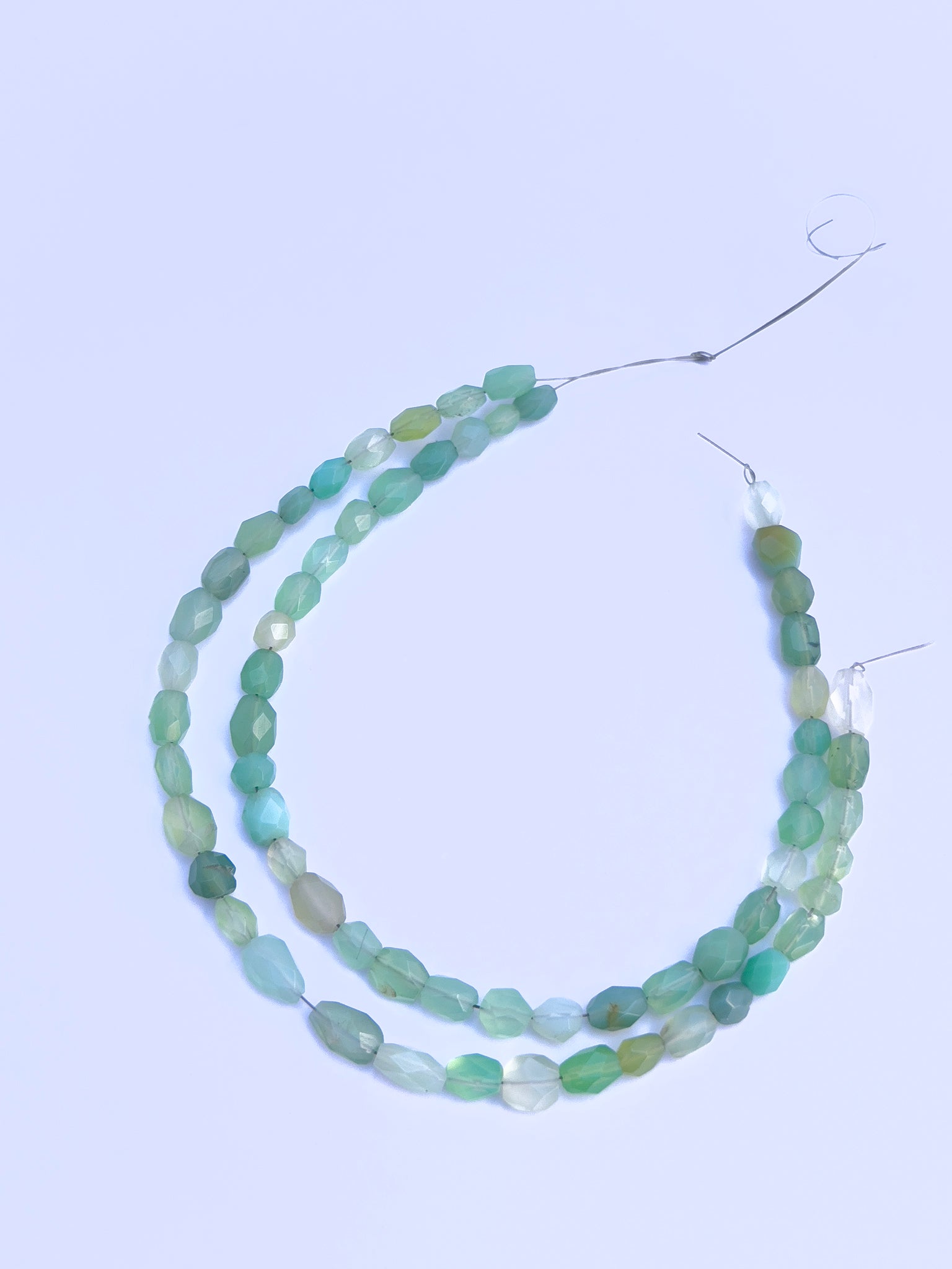 Stone beads in Green Chalcedony finish laid flat to highlight their 4.5×6mm to 5.5×7.5mm size and faceting.