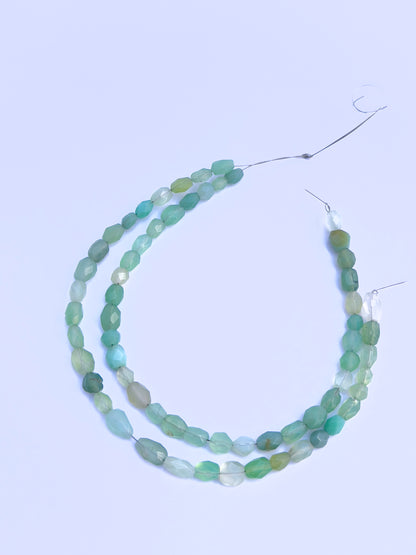 Stone beads in Green Chalcedony finish laid flat to highlight their 4.5×6mm to 5.5×7.5mm size and faceting.