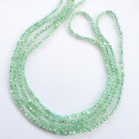 Close-up of Green Chalcedony faceted rondelle beads with fresh green tones and sparkling facets.