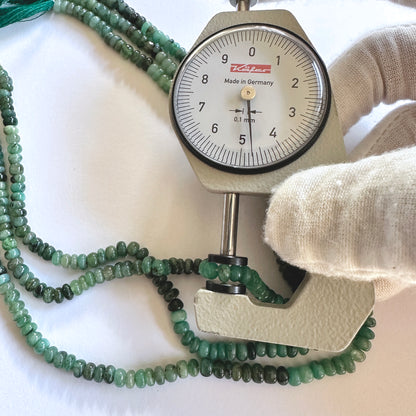 A dial gauge measures the Green Emerald rondelle 4.5-4.9mm gemstone.
