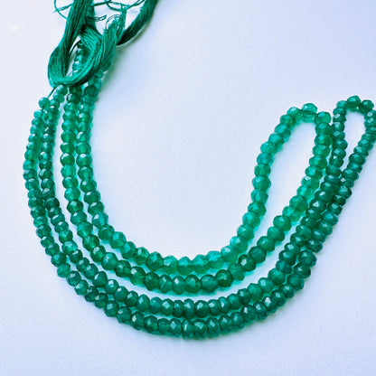 Green onyx stone beads with faceted rondelle cut and vibrant green tones for elegant handmade jewellery components.