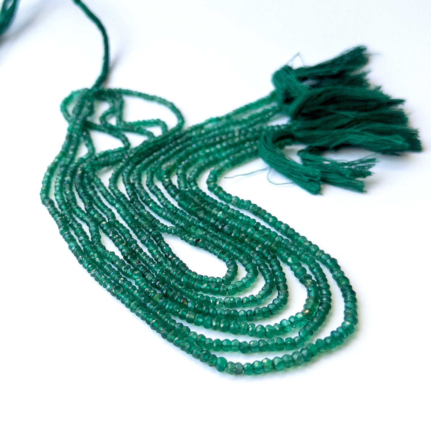 Genuine Green Onyx gemstone beads showcasing faceted rondelle cuts arranged neatly on a 34cm strand.