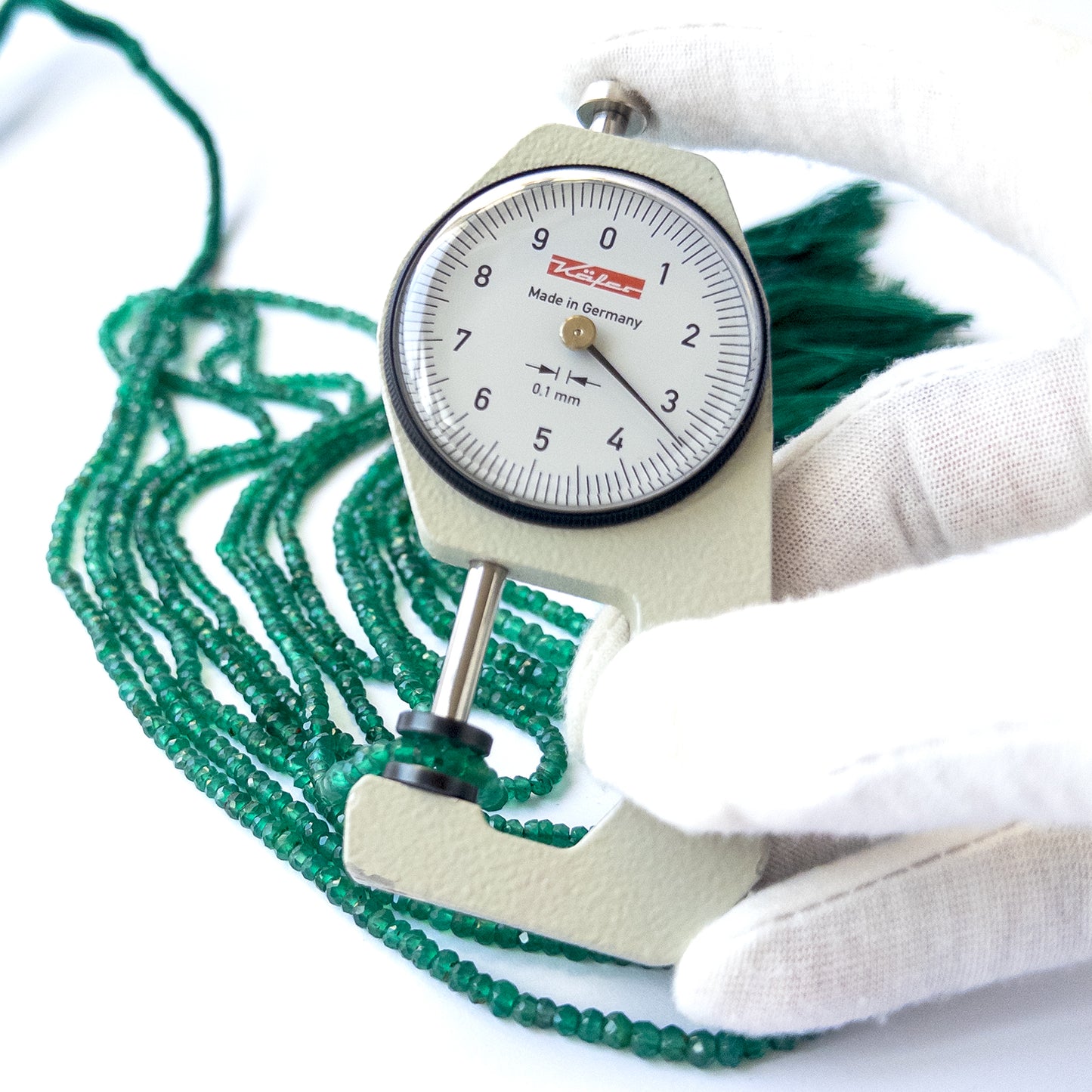A dial gauge measures the Green Onyx faceted rondelle 3–4.4mm gemstone.