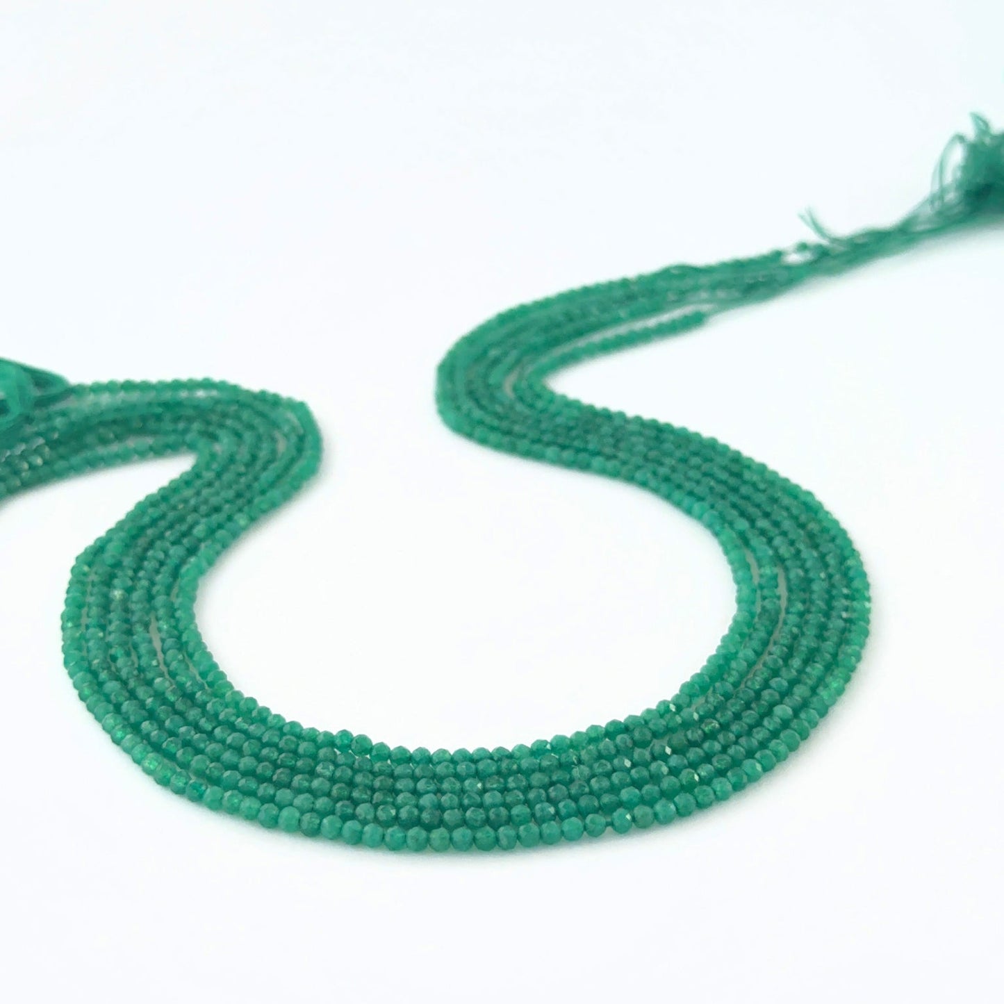 Micro‑faceted Green Onyx rondelle beads arranged neatly, highlighting their polished finish and handmade jewellery component quality.