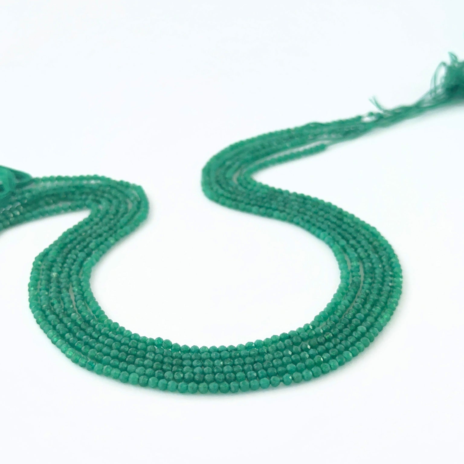 Micro‑faceted Green Onyx rondelle beads arranged neatly, highlighting their polished finish and handmade jewellery component quality.
