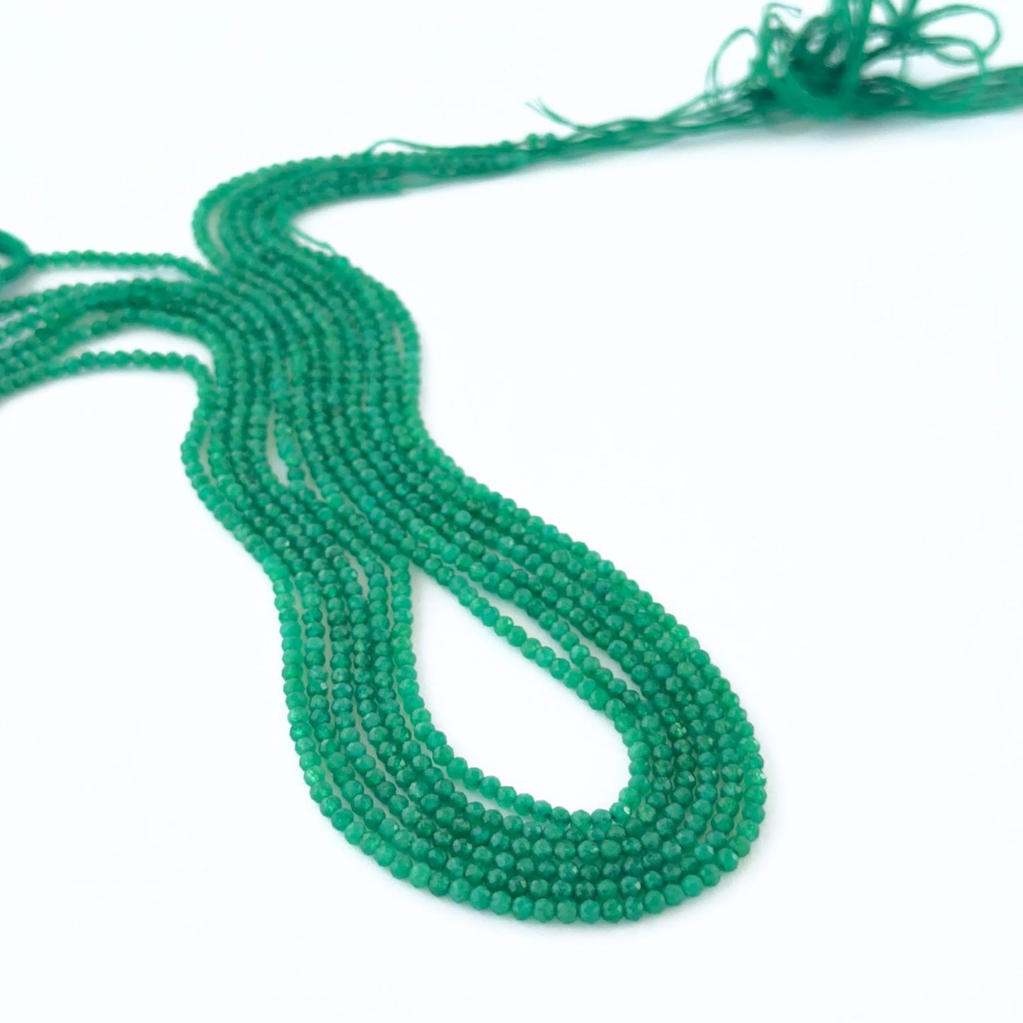 Green Onyx micro‑faceted rondelle beads in a long strand, displaying vibrant colour and refined craftsmanship