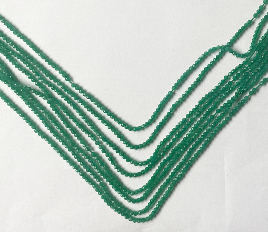 Radiant micro-faceted rondelle beads showcasing a brilliant emerald-green glow and refined shimmer.