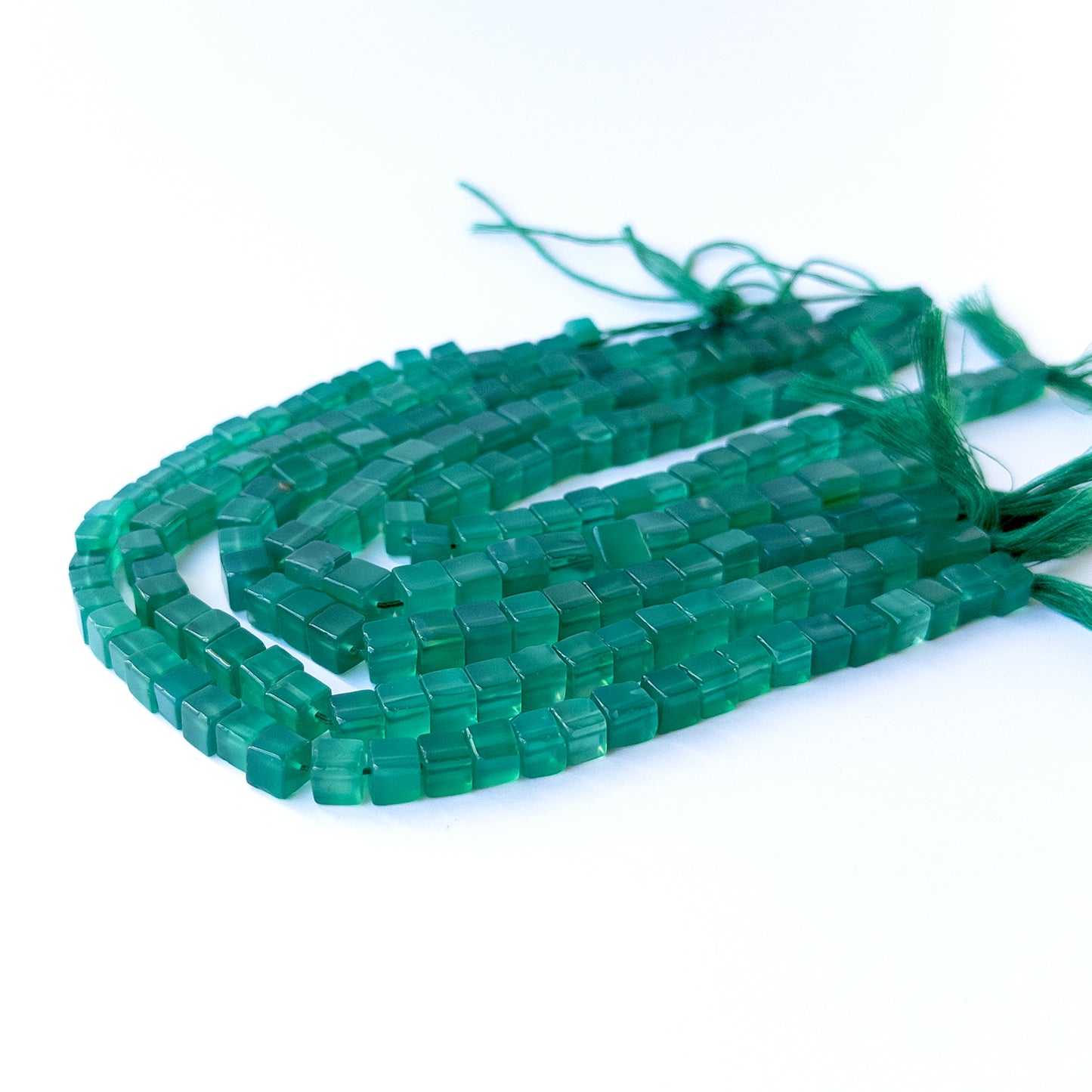 Authentic green onyx gemstone beads showcasing rich green tones and uniform cube cuts.