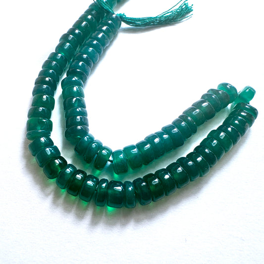 Close-up of Green Onyx stone beads with smooth wheel cut, showcasing deep green tones for handmade jewellery components.