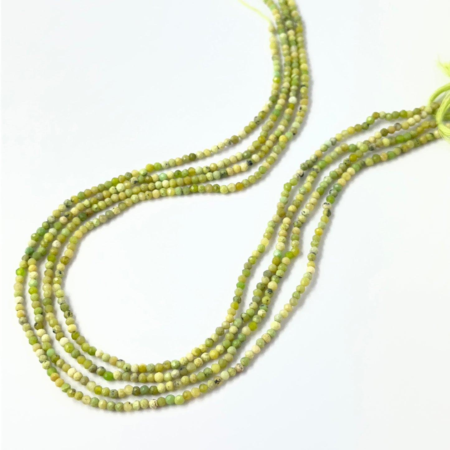 Green Opal faceted rondelle gemstone beads in 2.2mm and 2.5mm sizes, arranged on a 32cm strand for handmade jewellery makers.