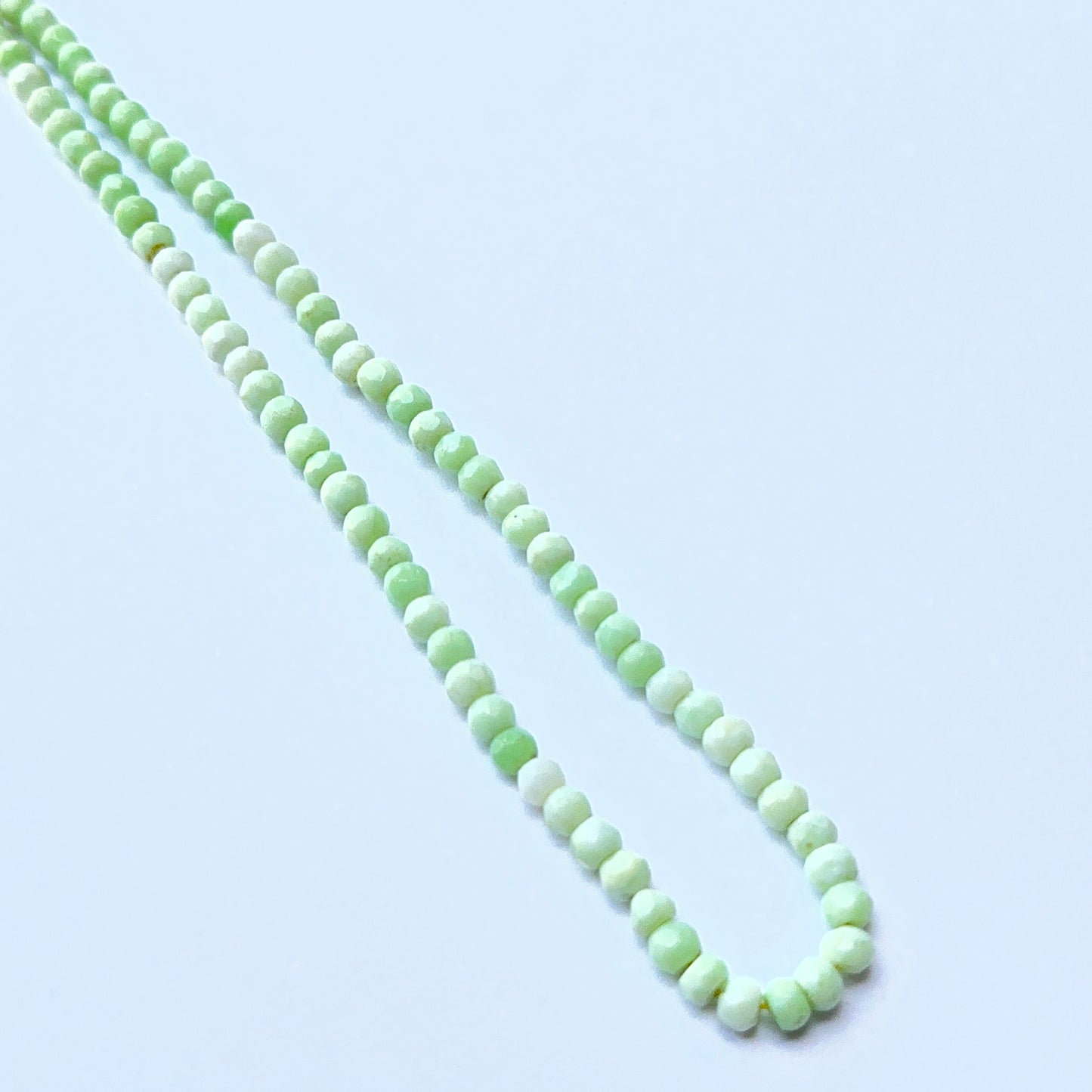 Green Opal 4.3–4.5mm faceted rondelle beads arranged on a strand, showing crisp faceting and earthy green tones.