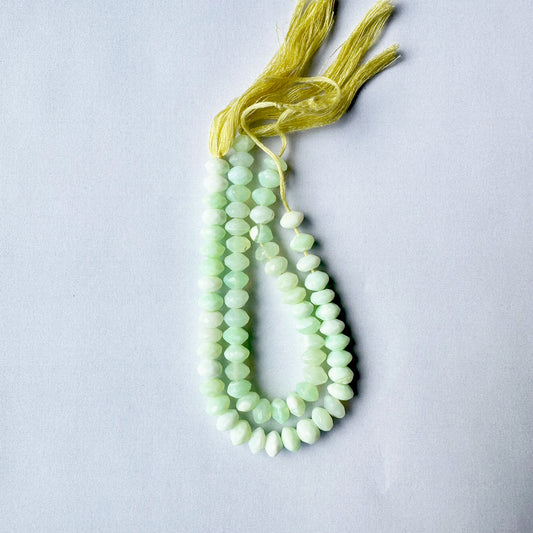Green Opal rondelle beads arranged in faceted alignment with consistent green tones and sparkle.