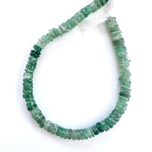 Close-up of Green Strawberry Quartz smooth wheel beads with soft green tones and polished finish.