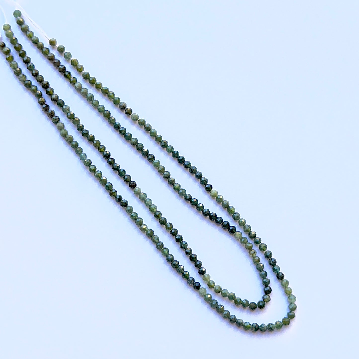 Close-up of green tourmaline 3.5mm faceted spheres highlighting crisp facets and bright colour for handmade jewellery components.