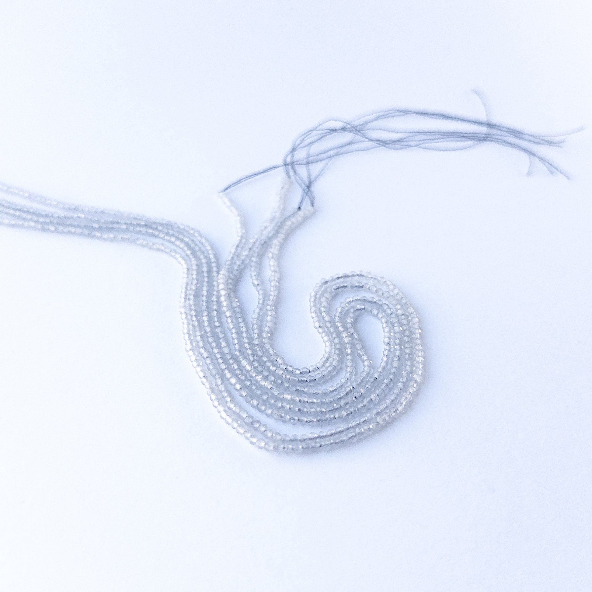 Close‑up of genuine Grey Chalcedony faceted rondelle beads showing their shine, clarity, and delicate 2.2mm cut.