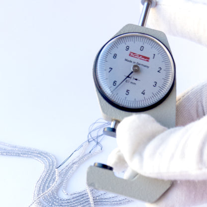 A dial gauge measures the Grey Chalcedony faceted rondelle 2.2mm gemstone.