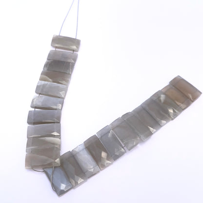 Grey Moonstone faceted rectangle gemstone on white background.