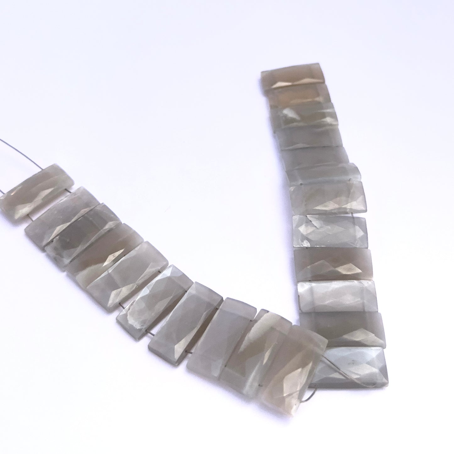 Grey Moonstone gemstone beads for jewellery making displayed with soft lighting.