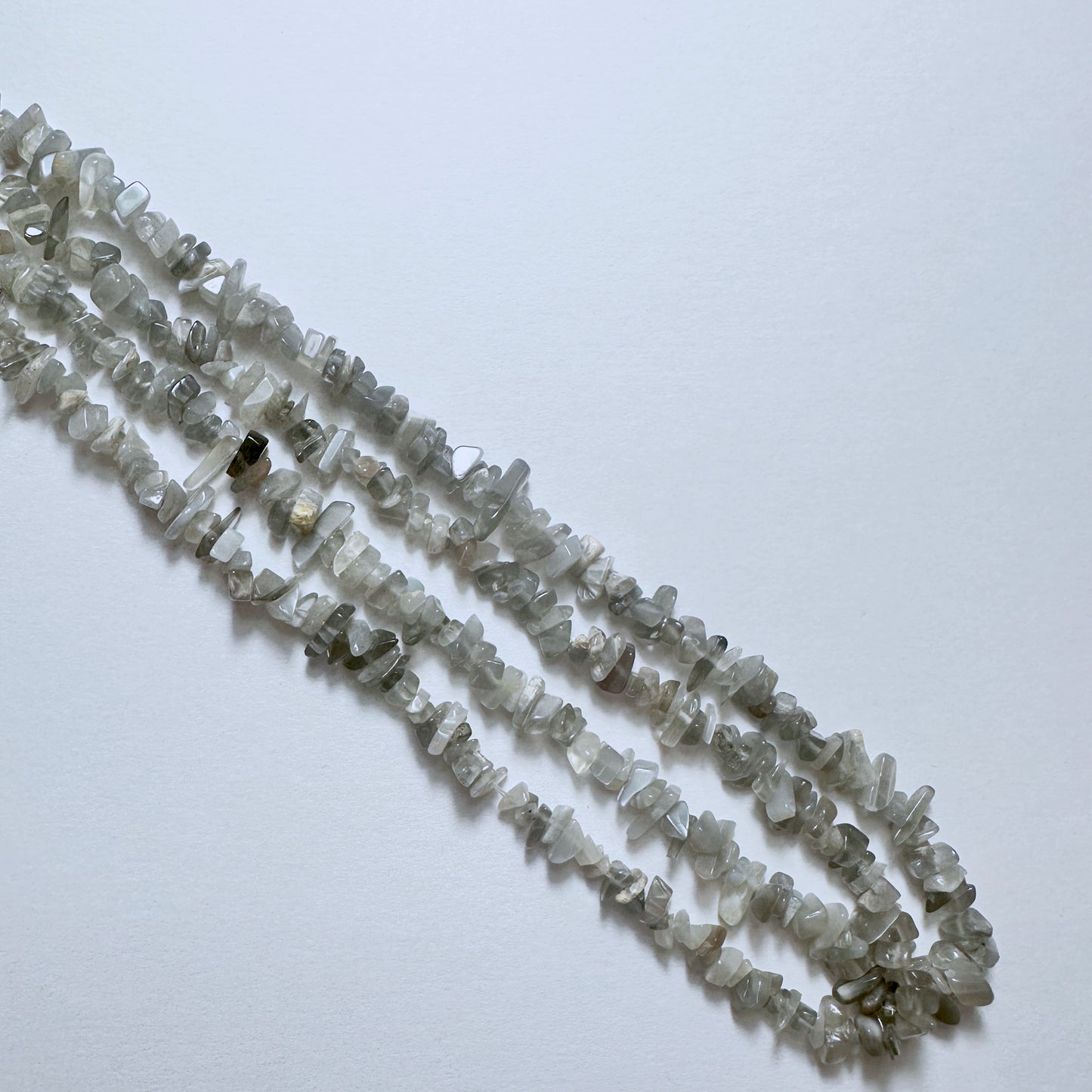 Natural gemstone beads for DIY jewellery featuring Grey Moonstone chips with subtle shimmer and organic texture.