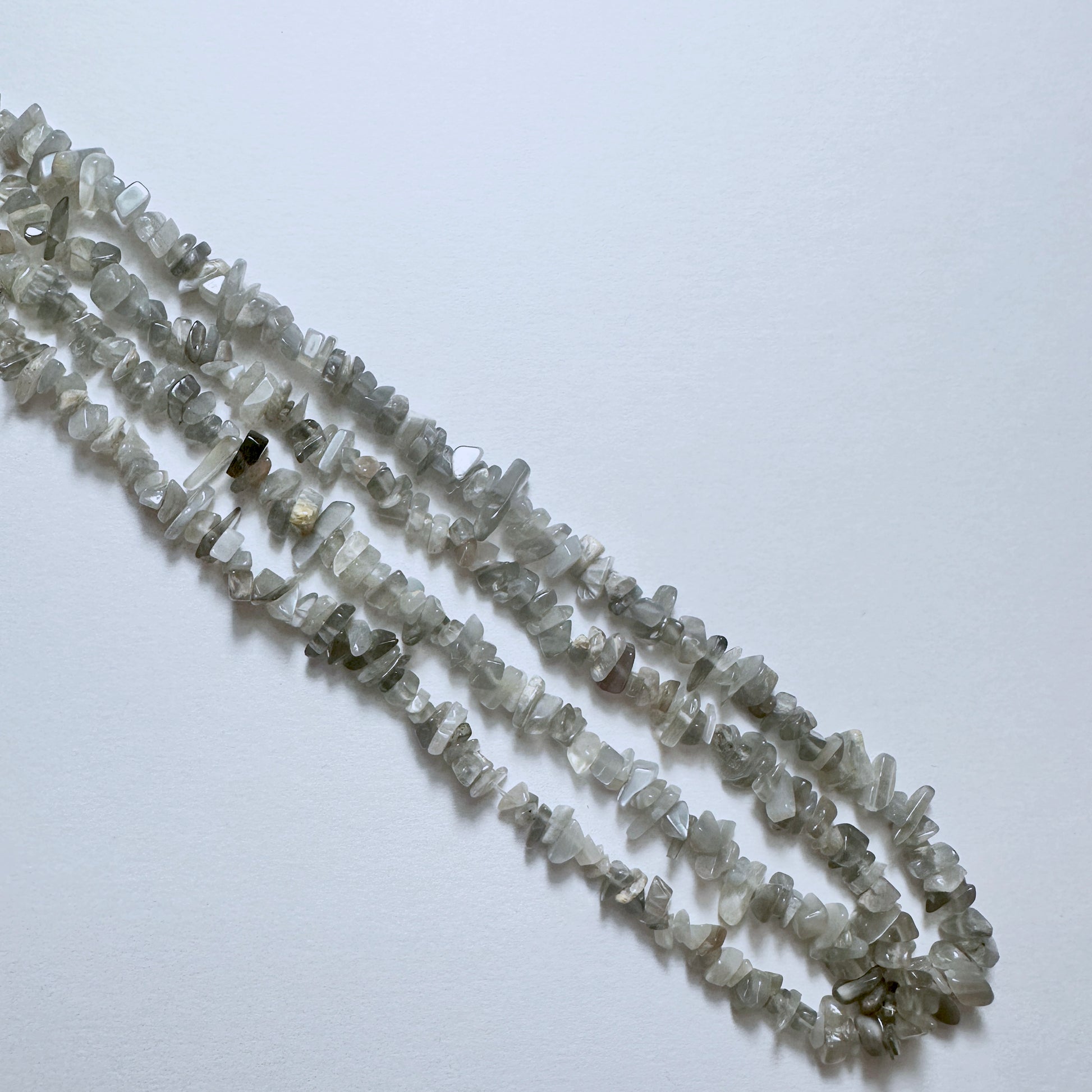 Natural gemstone beads for DIY jewellery featuring Grey Moonstone chips with subtle shimmer and organic texture.