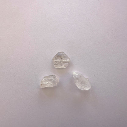 A dial gauge measures the Herkimer Diamond rough cut 9-12mm gemstone.