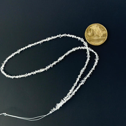 2mm Herkimer Diamond chips held for scale, showcasing high-clarity gemstone beads for artisan jewellery.