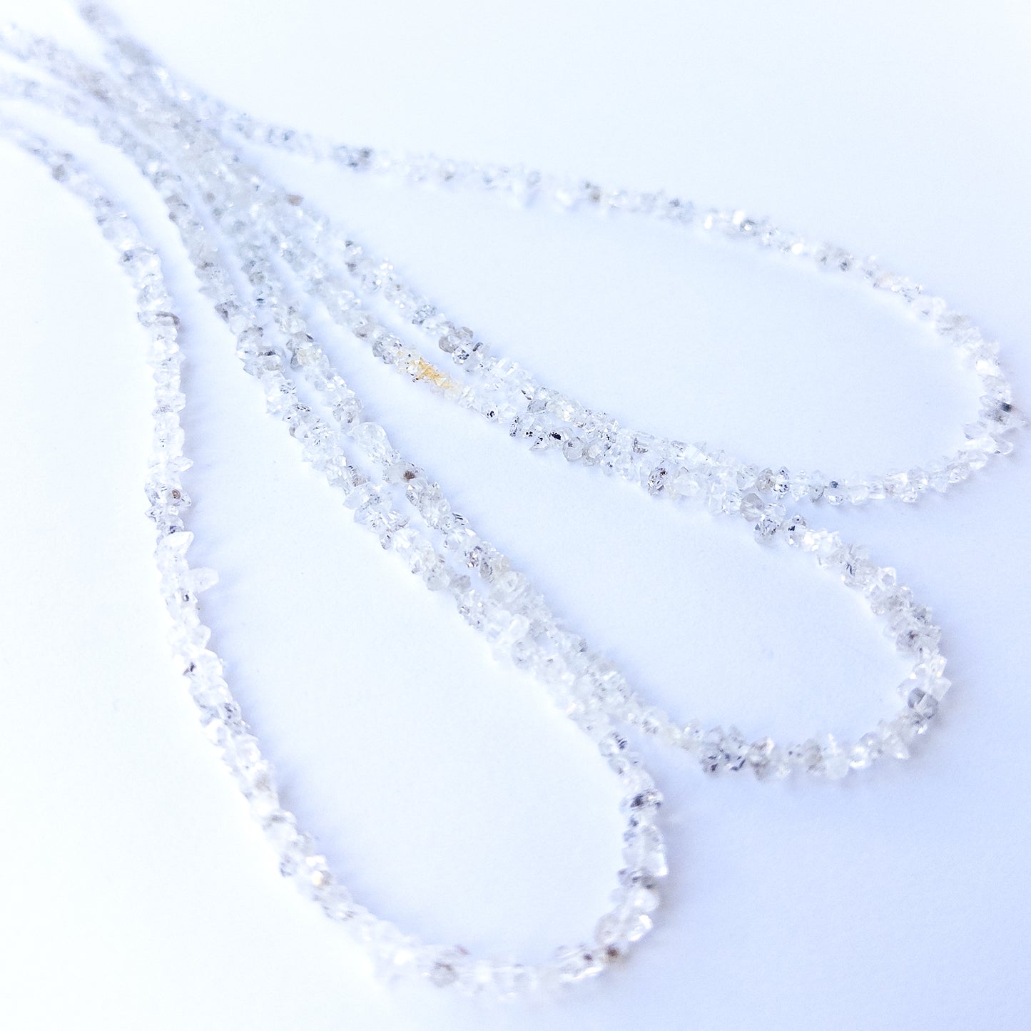 Close‑up of genuine Herkimer Diamond chip beads highlighting their clarity, sparkle and natural crystal form.