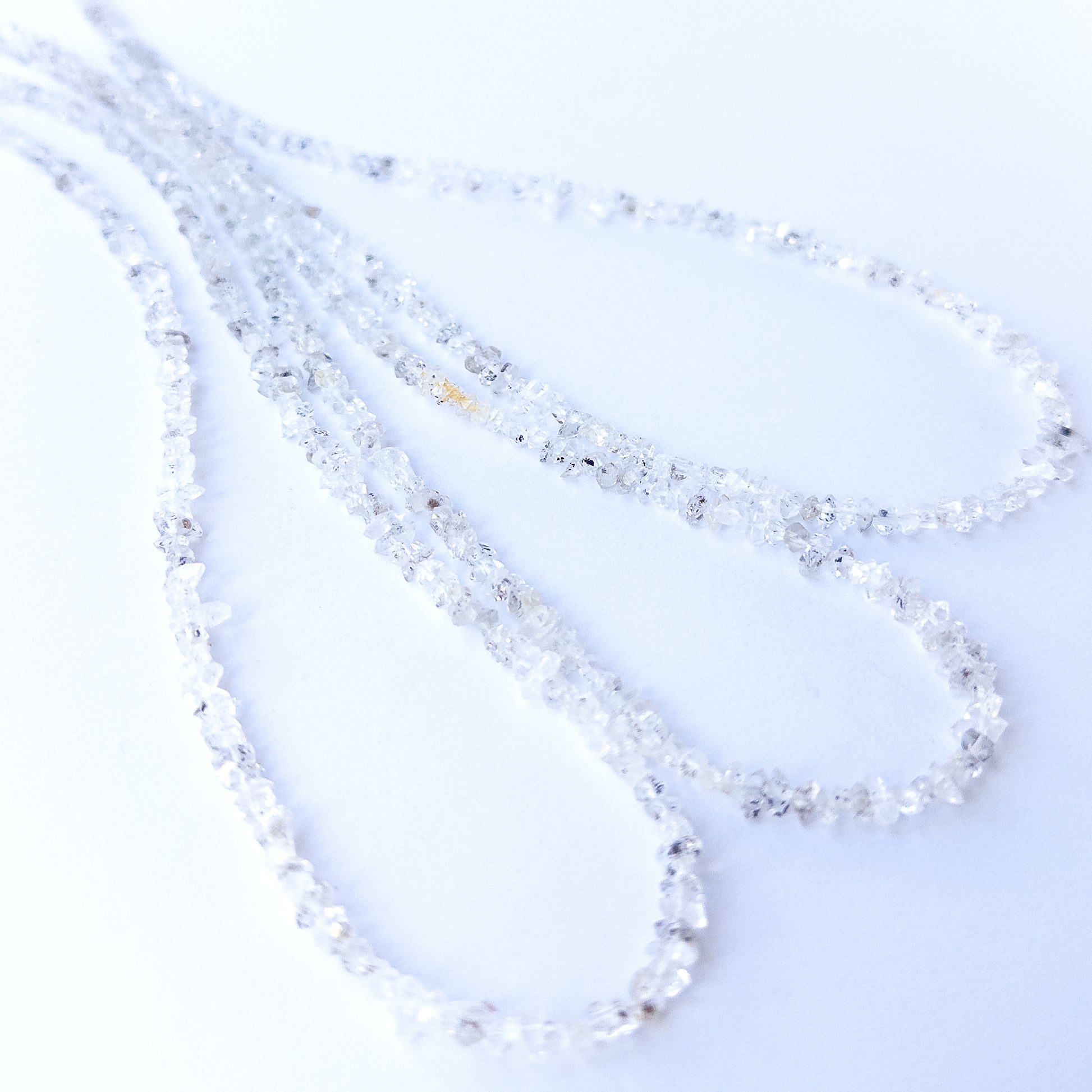 Close‑up of genuine Herkimer Diamond chip beads highlighting their clarity, sparkle and natural crystal form.