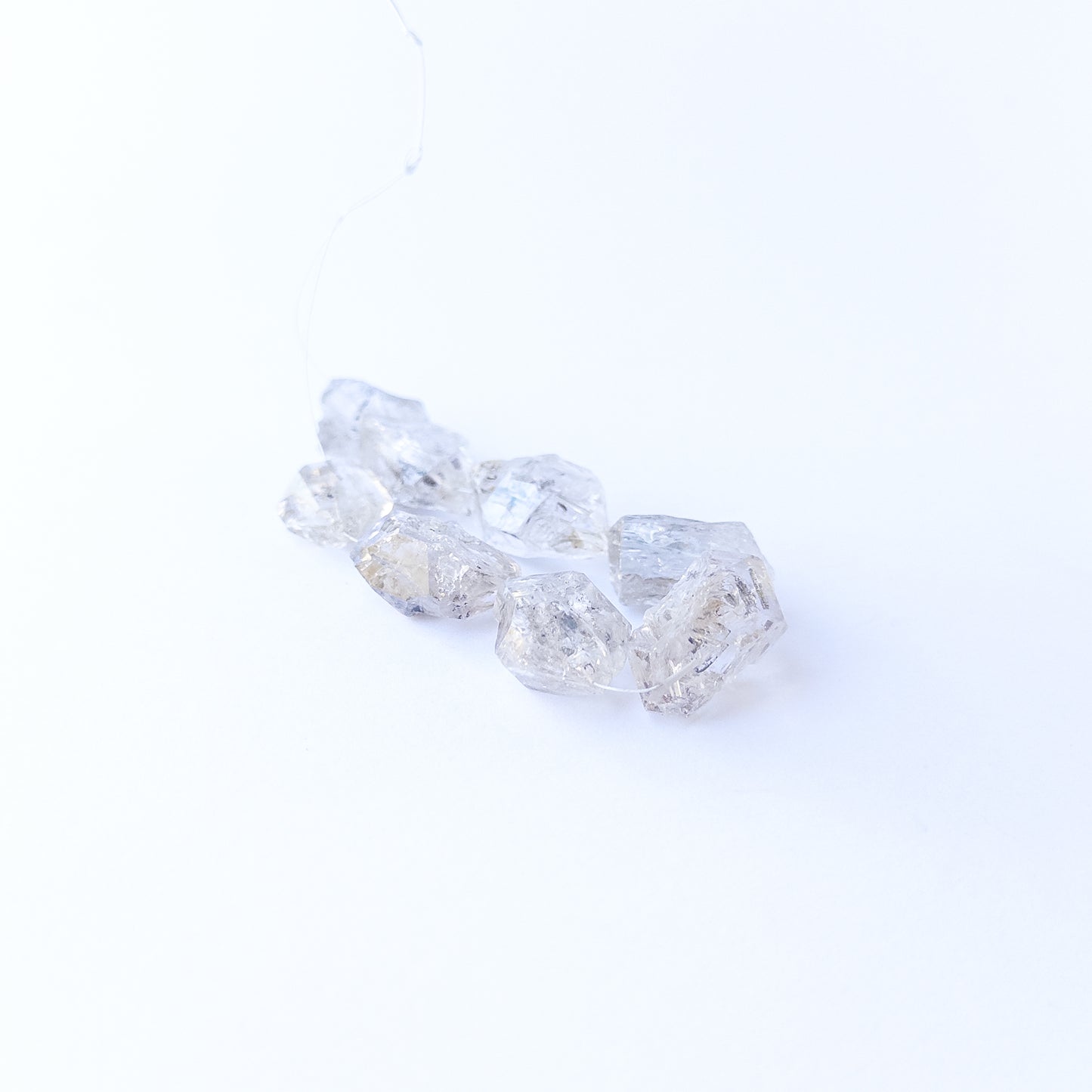 Premium Herkimer Diamond drilled rough stones with striking clarity and rugged faceted surfaces.