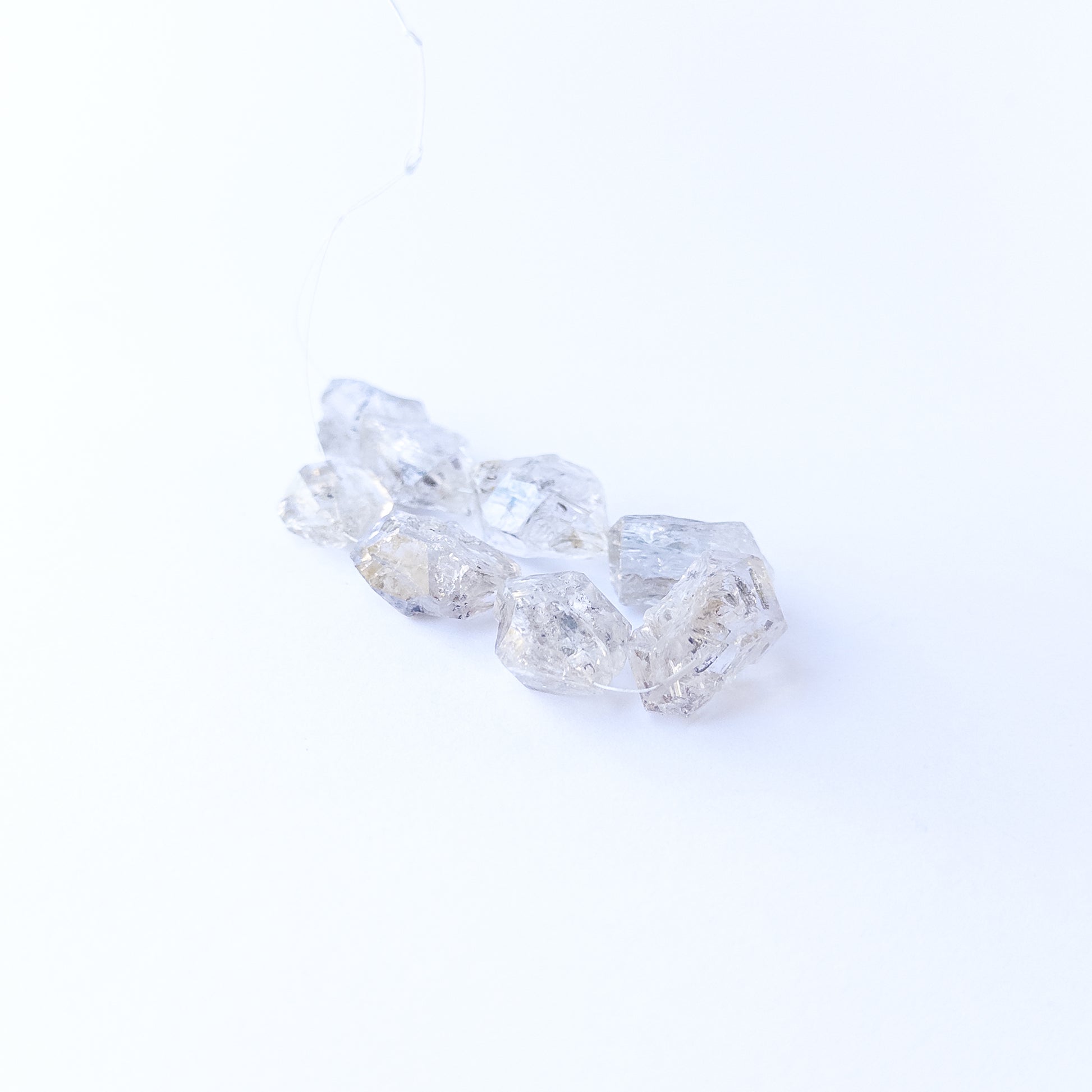 Premium Herkimer Diamond drilled rough stones with striking clarity and rugged faceted surfaces.