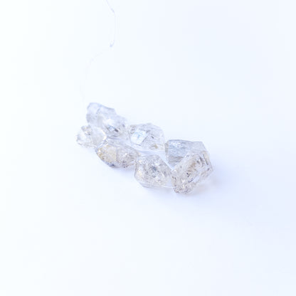 Premium Herkimer Diamond drilled rough stones with striking clarity and rugged faceted surfaces.