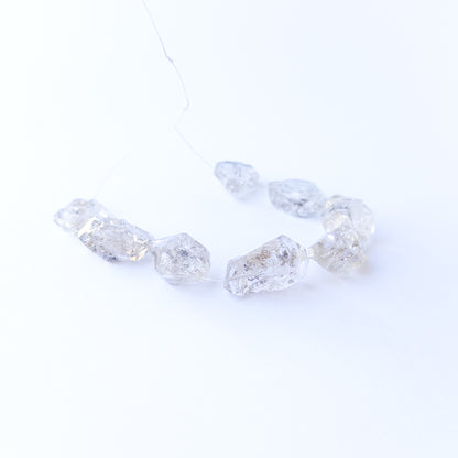 Herkimer Diamond gemstone beads arranged in a set of five, displaying their unique double‑terminated shape.