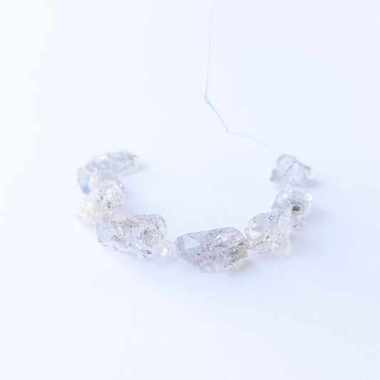 Authentic Herkimer Diamond rough stone beads arranged to highlight their angular crystal form.