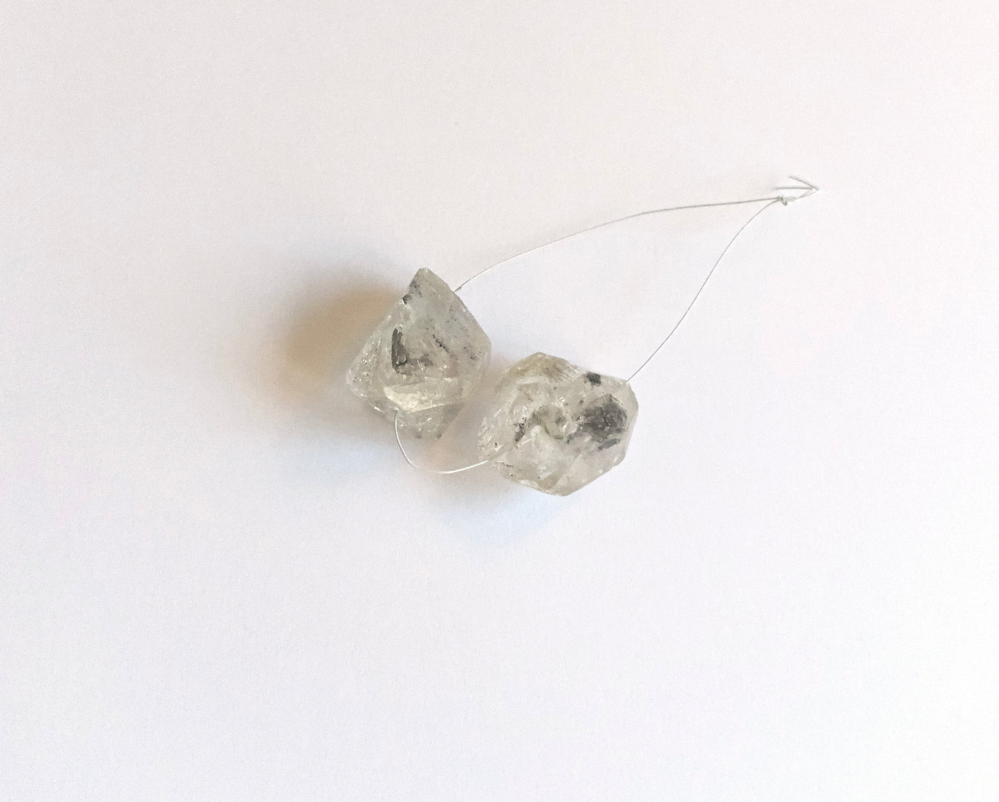 Detailed view of 25x21mm drilled Herkimer Diamond beads with radiant crystal facets. Stone beads with natural brilliance and drilled holes, ideal for bold jewellery designs. 