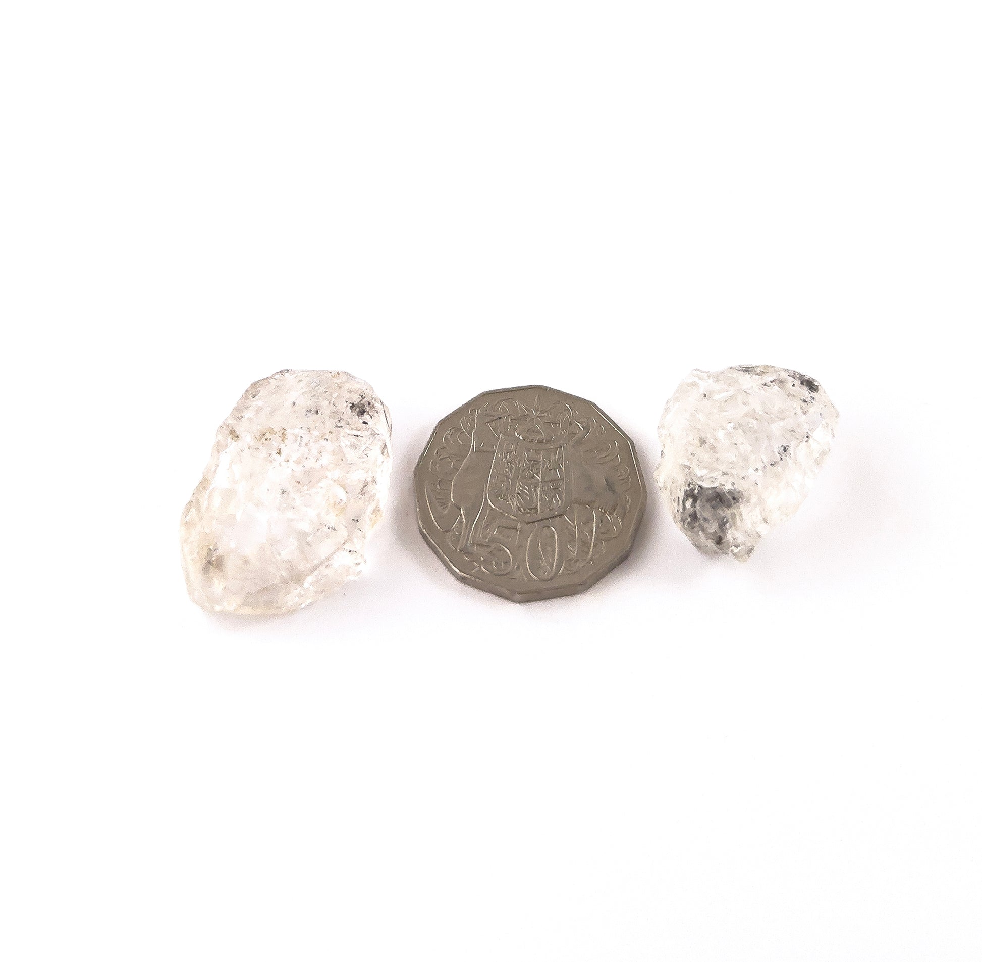 A coin is placed near delicate pieces of Herkimer Diamond rough for scale.