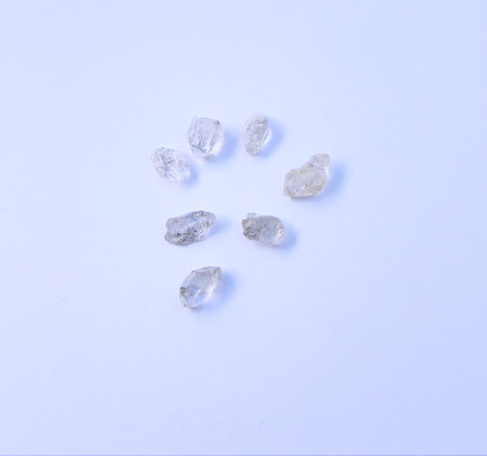 Close-up of 7 Herkimer Diamond stone beads featuring raw crystal texture and organic shapes. 