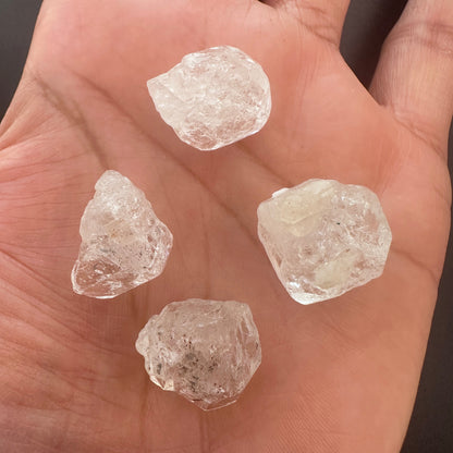 A person holds delicate strands of Herkimer beads, showcasing their rough organic design.