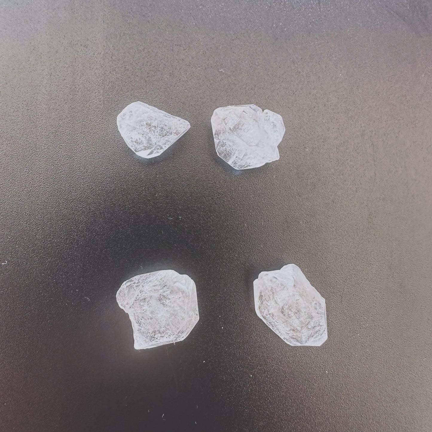 Four-piece Herkimer rough crystal set arranged to highlight size variation and natural form.