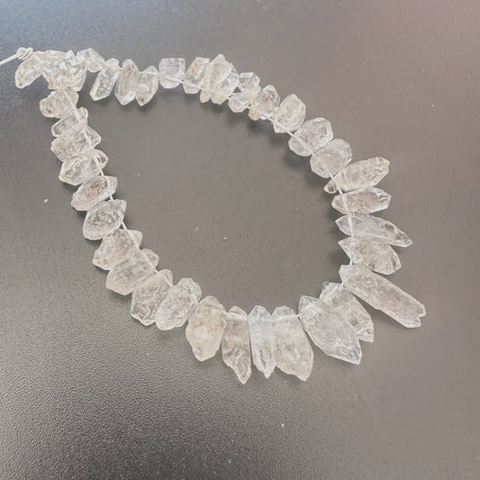 Natural Herkimer diamonds with 0.5mm bead holes displayed on a jewellery mat.
