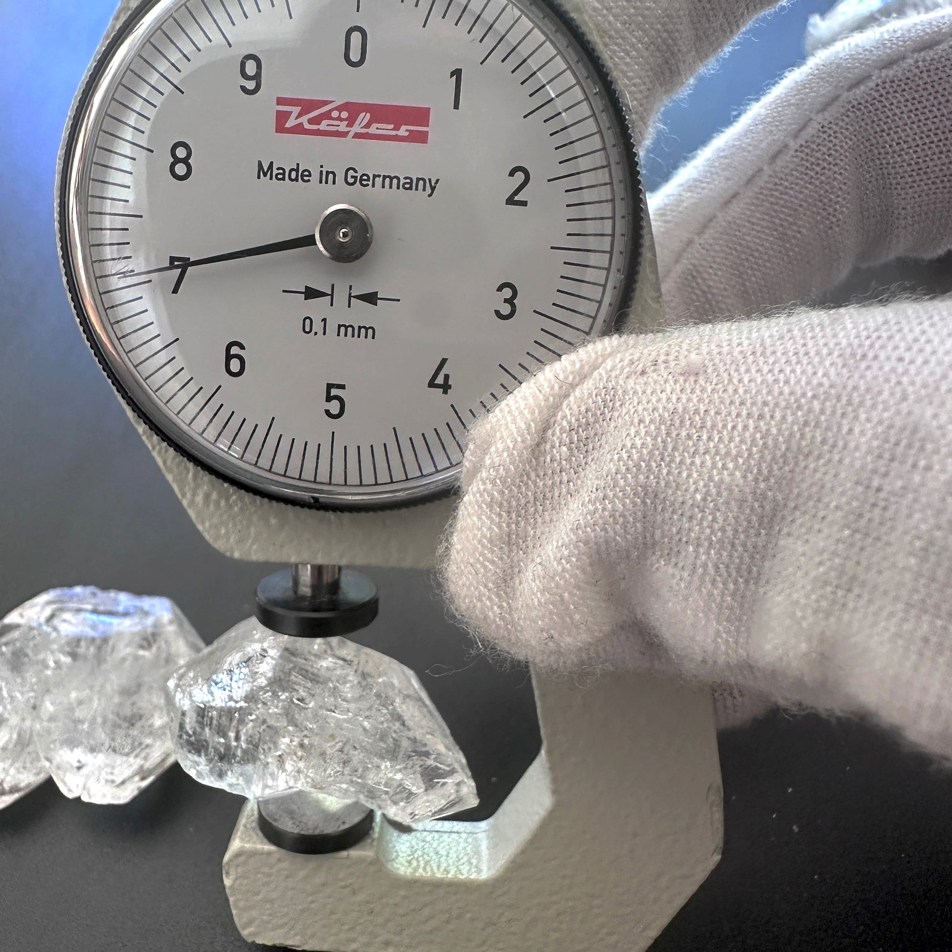 A dial gauge measures the Herkimer rough cut gemstone